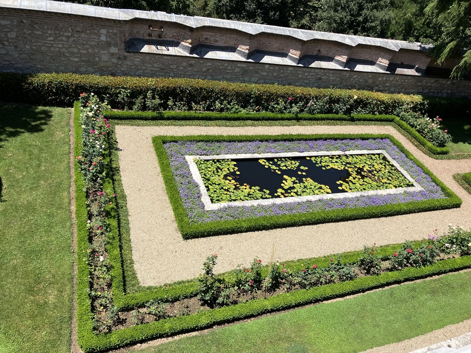 Beautifully manicured garden with a lily pond at the center.