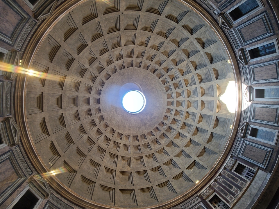 Interior dome with a central opening, featuring intricate patterns.