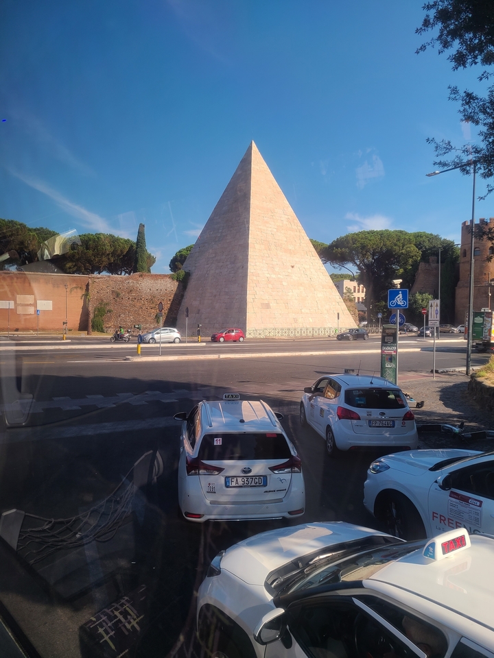 Ancient pyramid-like structure next to a modern road.