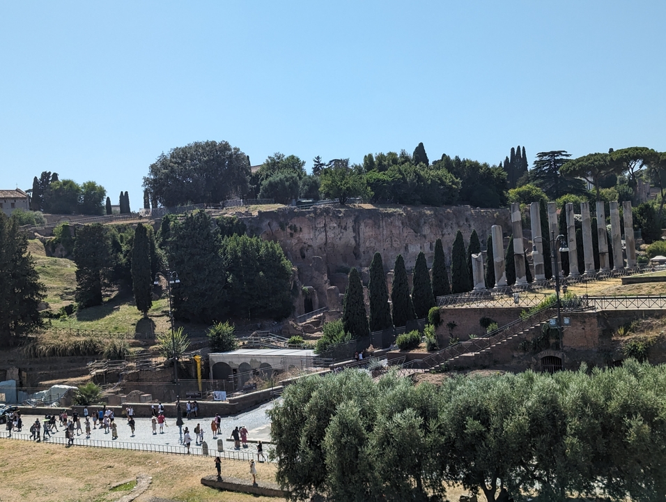 Ancient ruins against a clear sky with trees.