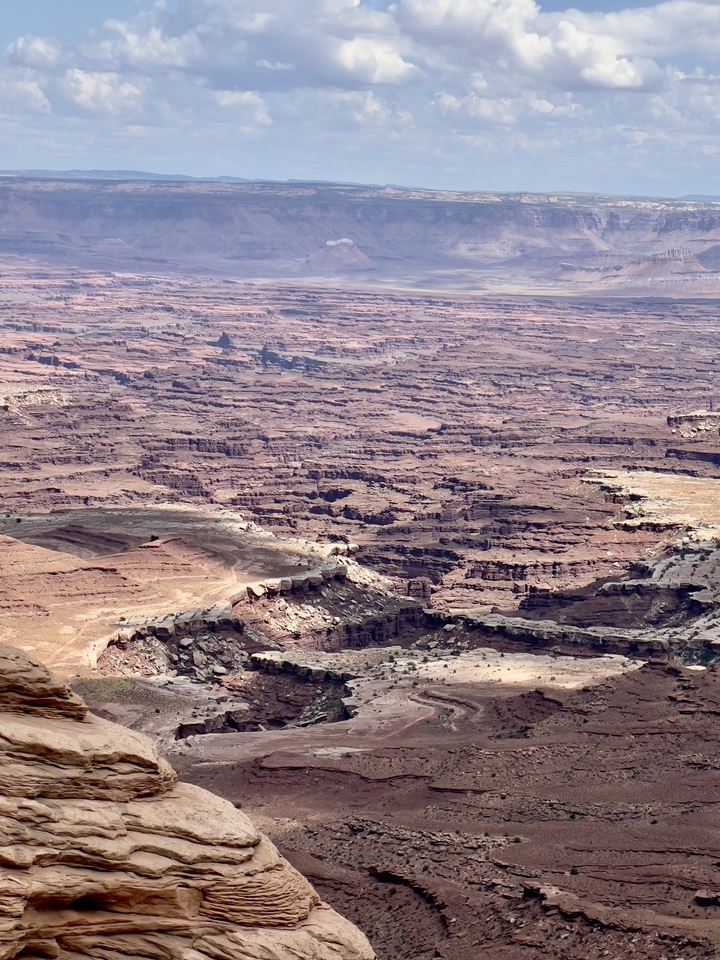 Vue panoramique d'un paysage de canyon avec des couches de formations rocheuses.