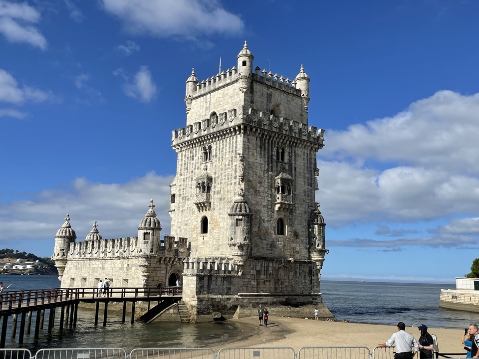 Historical tower by the water with clear sky.