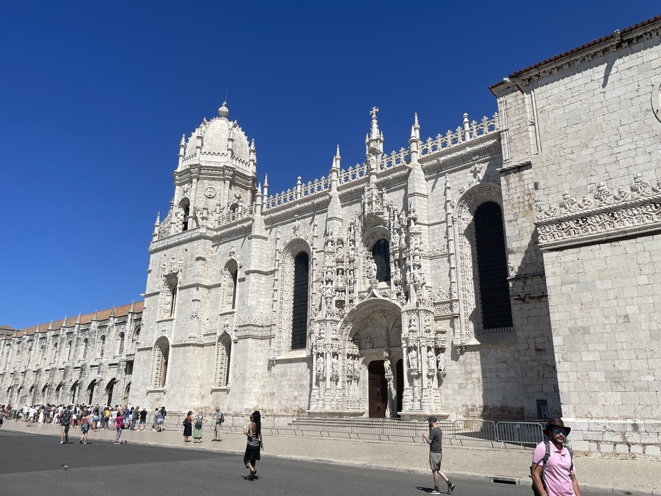 Large historical building with intricate carvings and tourists.