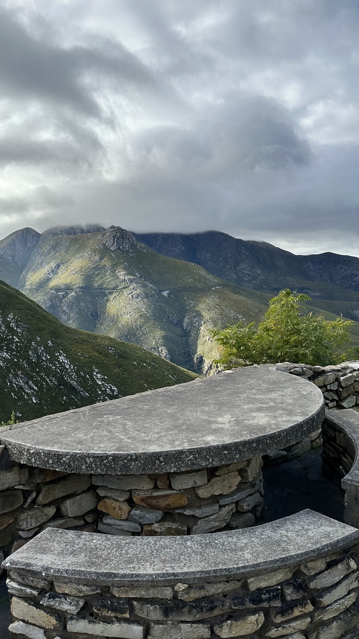 Mountainous landscape with clouds and greenery.