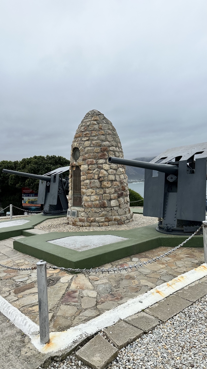 Stone monument with cannons by the sea.