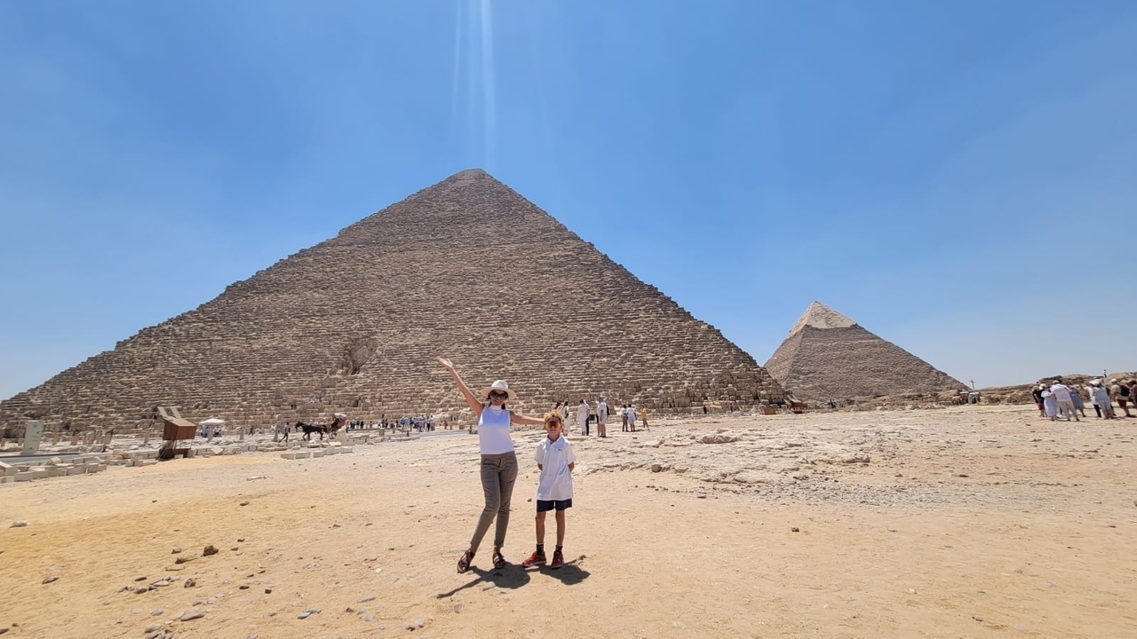 People posing near the pyramids in the desert.