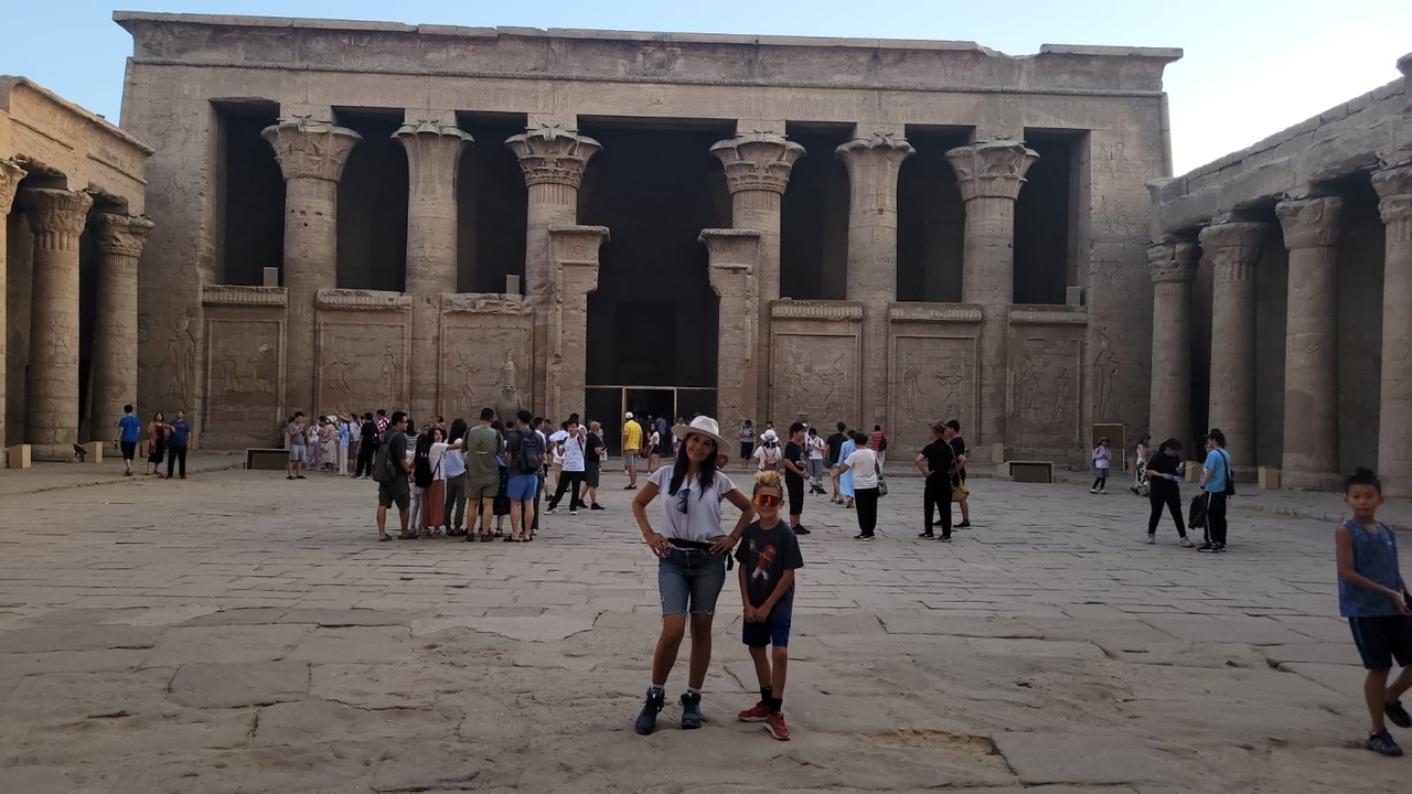 People posing in front of massive ancient Egyptian columns.