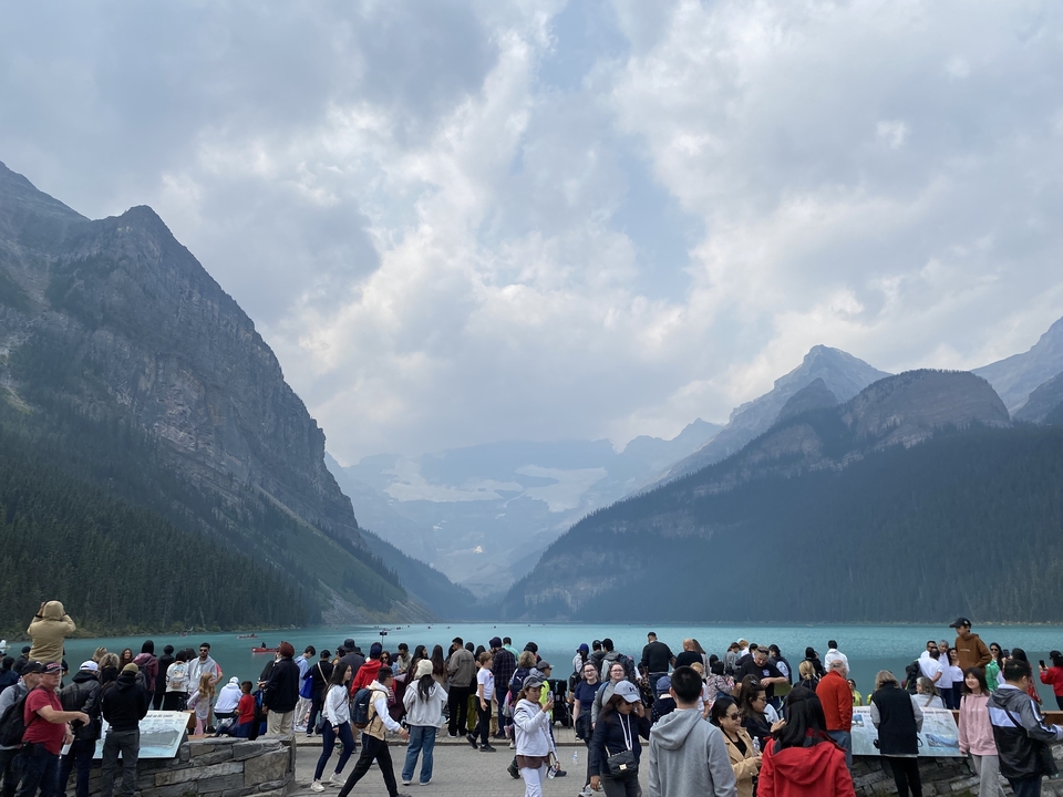 Vue panoramique du lac Louise avec montagnes et foule.