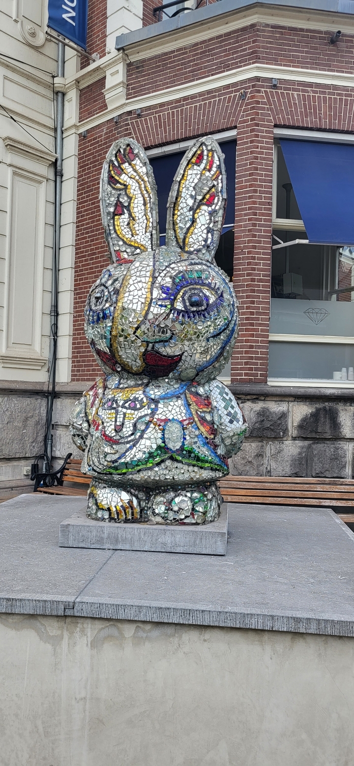 Colorful mosaic statue in front of a building.