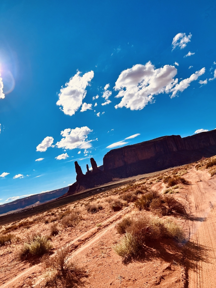 Monument Valley with blue sky and scattered clouds.