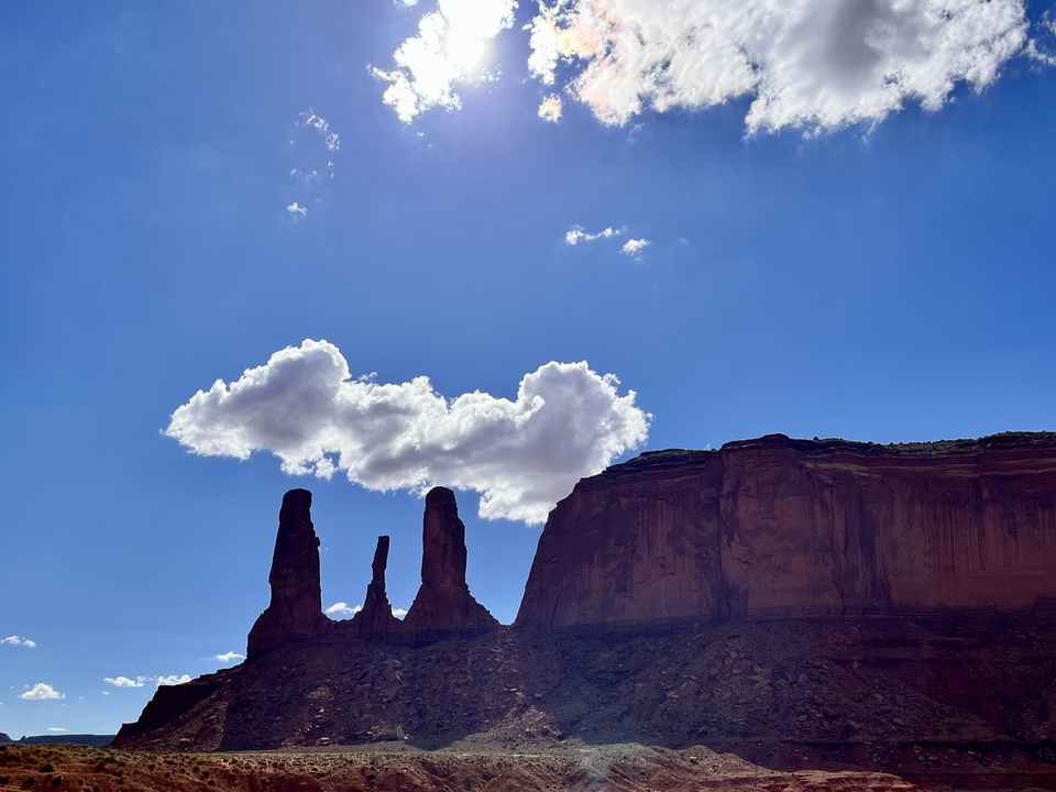 Monument Valley rock formations against a sunny sky.