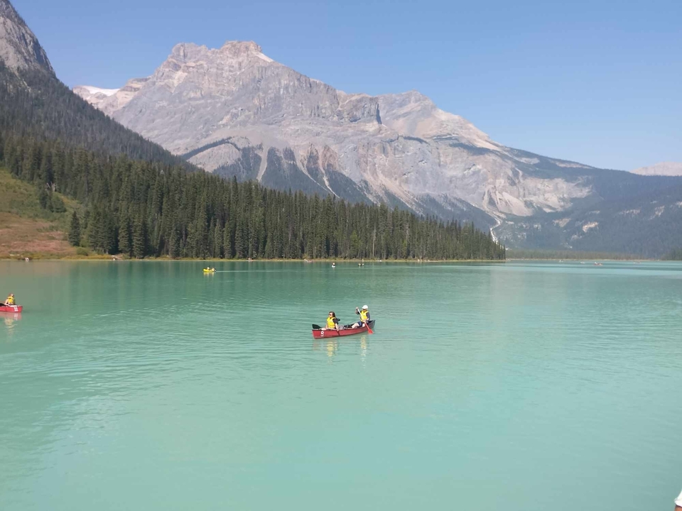 Canoës sur un lac turquoise entouré de montagnes