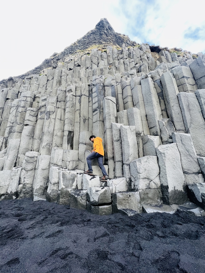 A person climbing basalt columns.