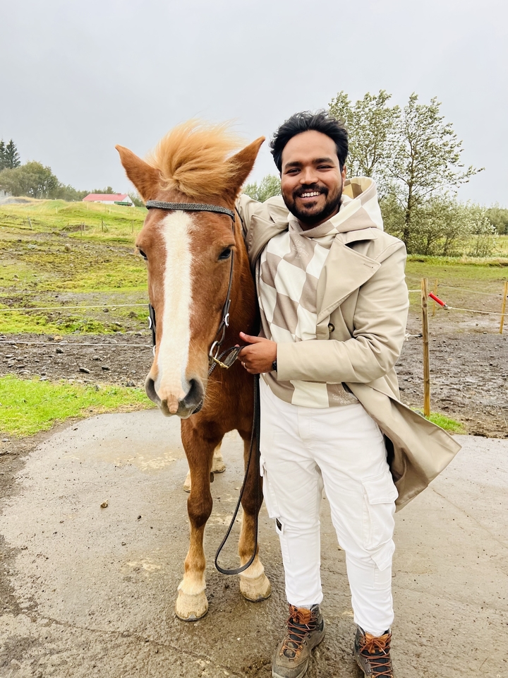 Man standing with a horse in a rural area.