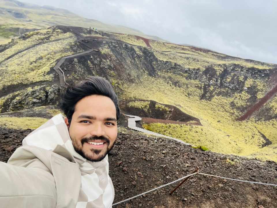 Selfie on a volcanic ridge with green moss surroundings.