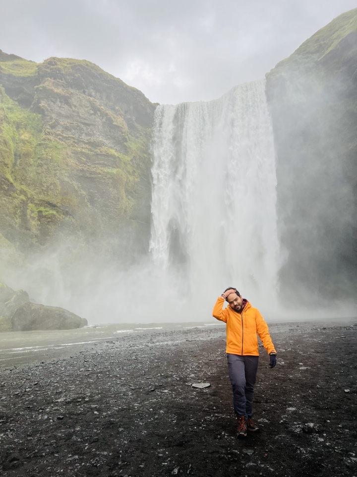 Man posing with waterfall in the background.