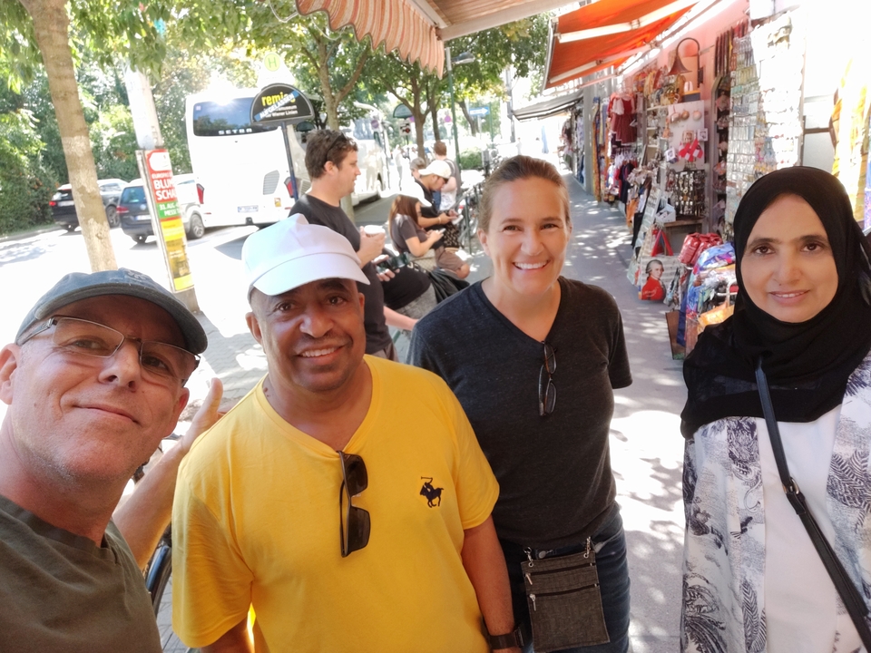 Groupe de touristes posant dans une rue de marché bondée.