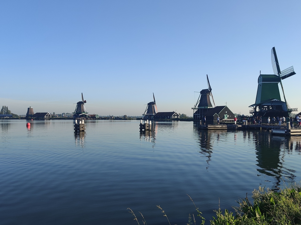 Vue panoramique de moulins à vent au-dessus d'un lac.