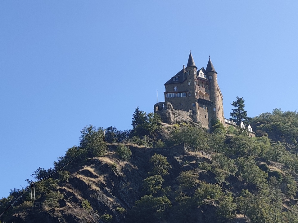 Château sur une colline sous un ciel bleu clair.