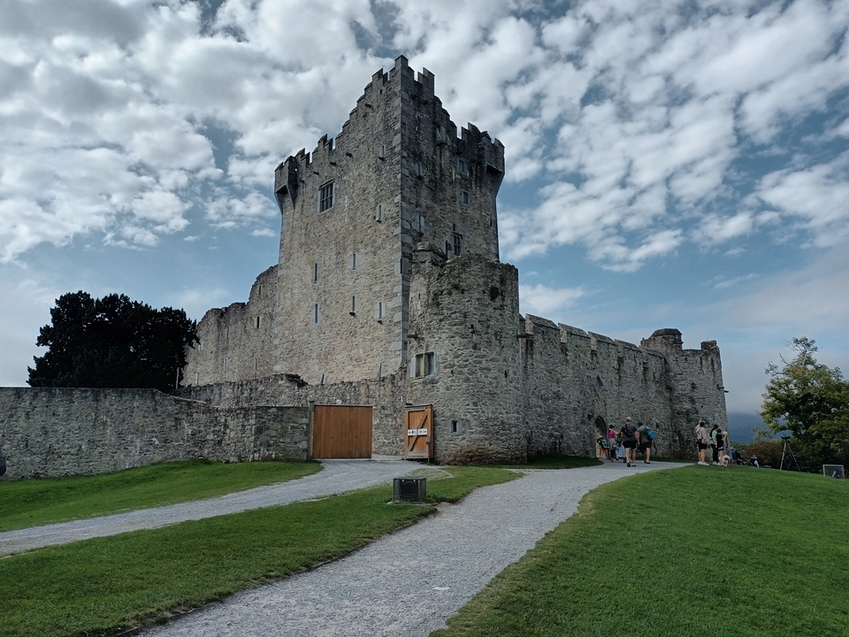 Un château historique avec des touristes à l'extérieur.