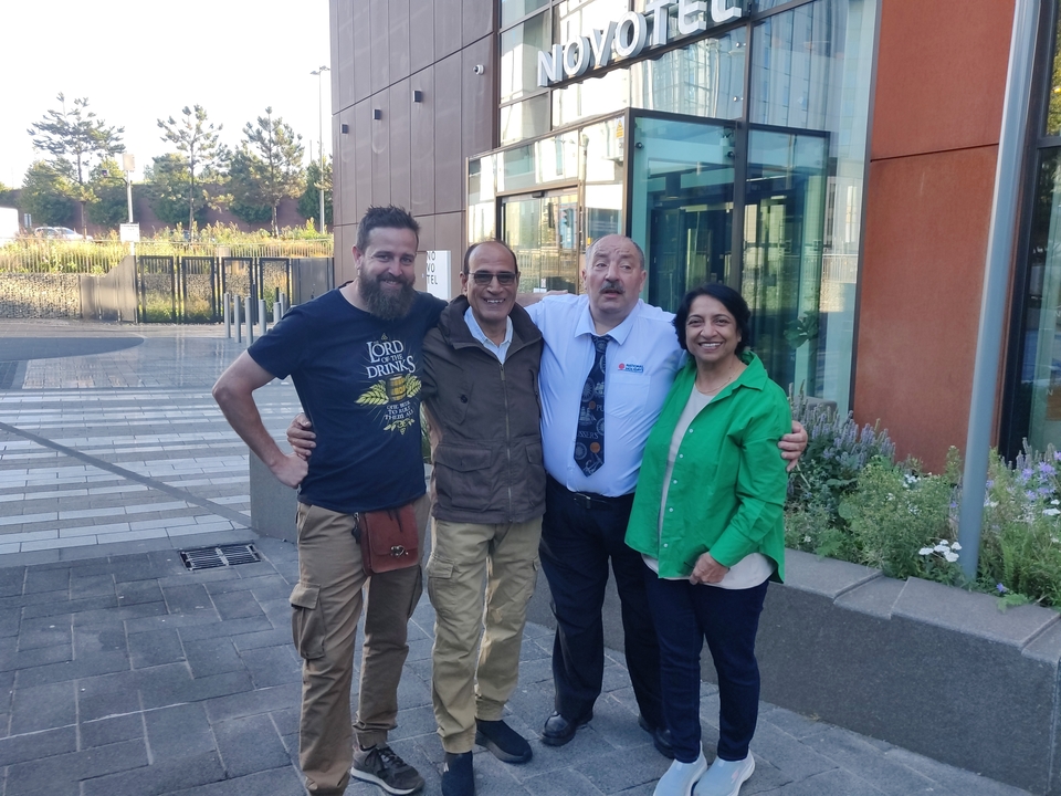 Group of people standing together in a modern outdoor setting.