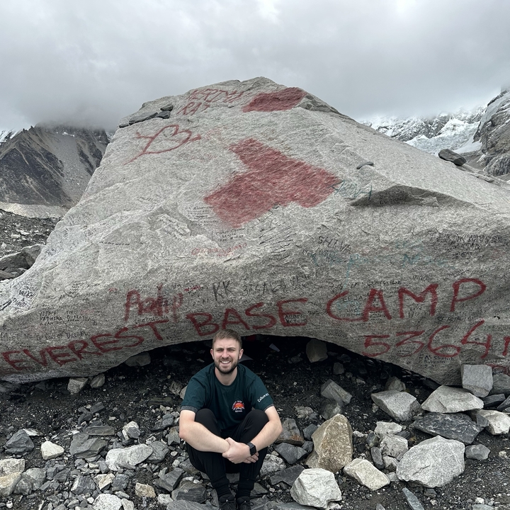 Person sitting in front of a rock at Everest Base Camp.