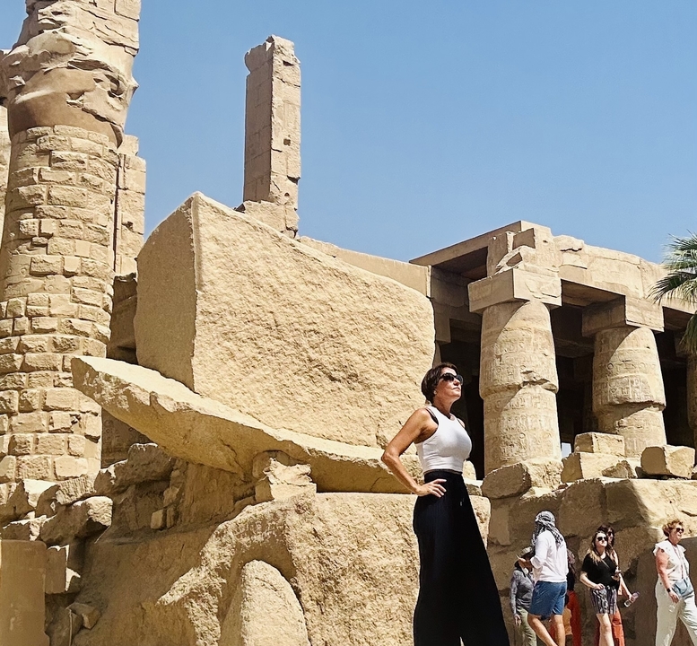 Personne posant près des colonnes de pierre anciennes d'un temple.