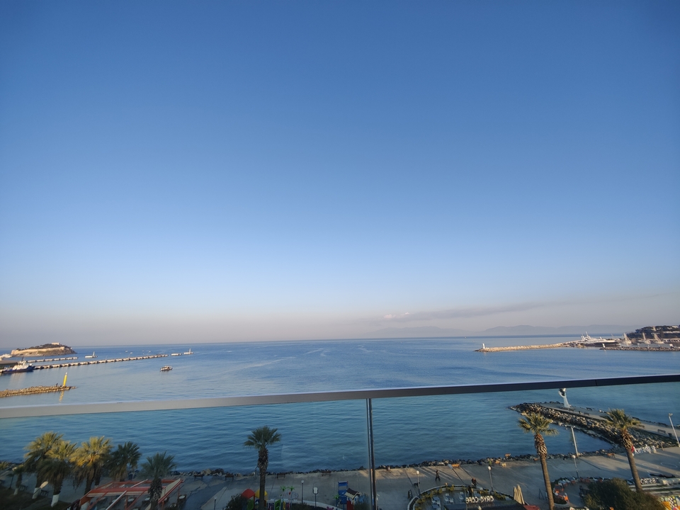 Coastal view with calm sea and distant ships.