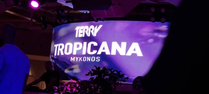 Illuminated nightclub interior with a sign reading 'Tropicana Mykonos'.