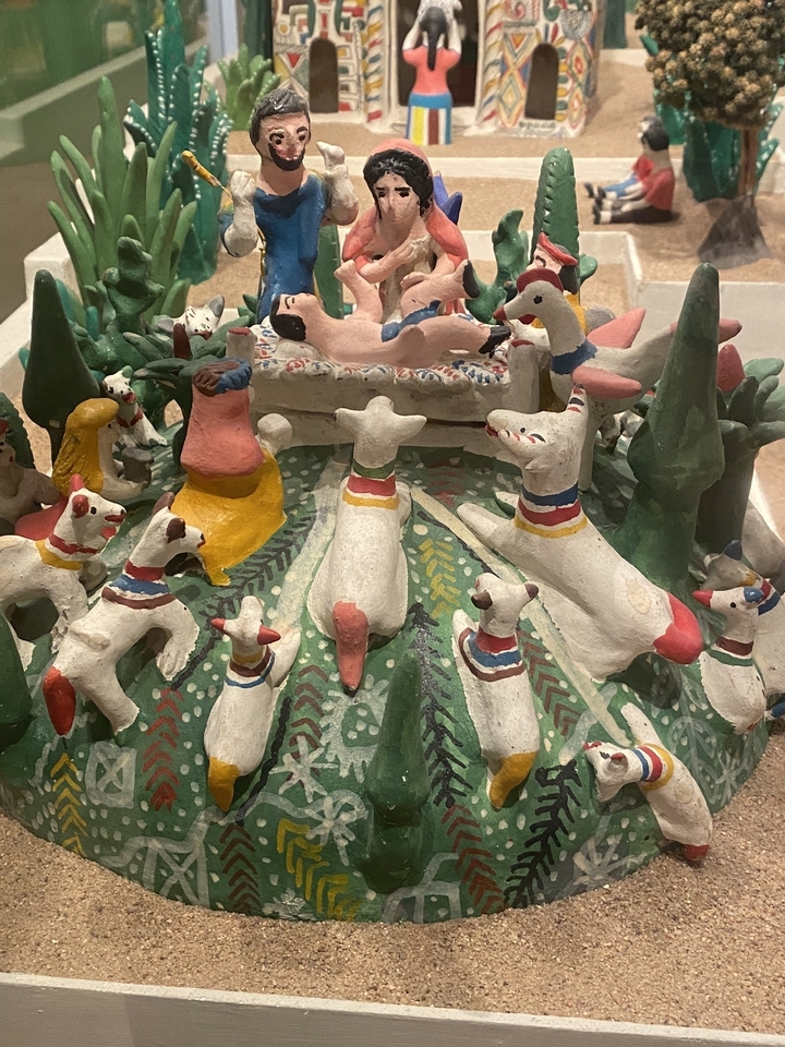 Des sculptures en argile colorées représentant une scène.