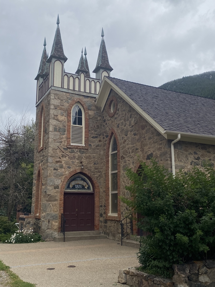 Église en pierre avec un ciel nuageux en arrière-plan.
