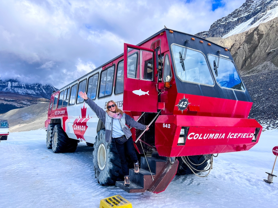 Personne avec un gros véhicule sur une surface enneigée.