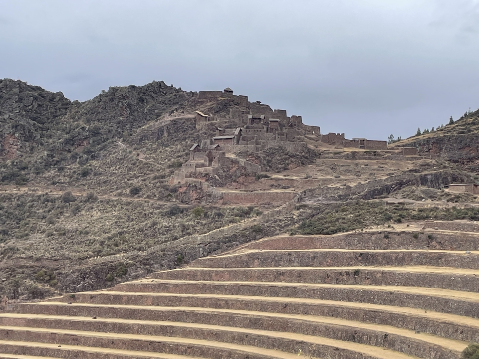 Ancient ruins on a hillside with terraces.