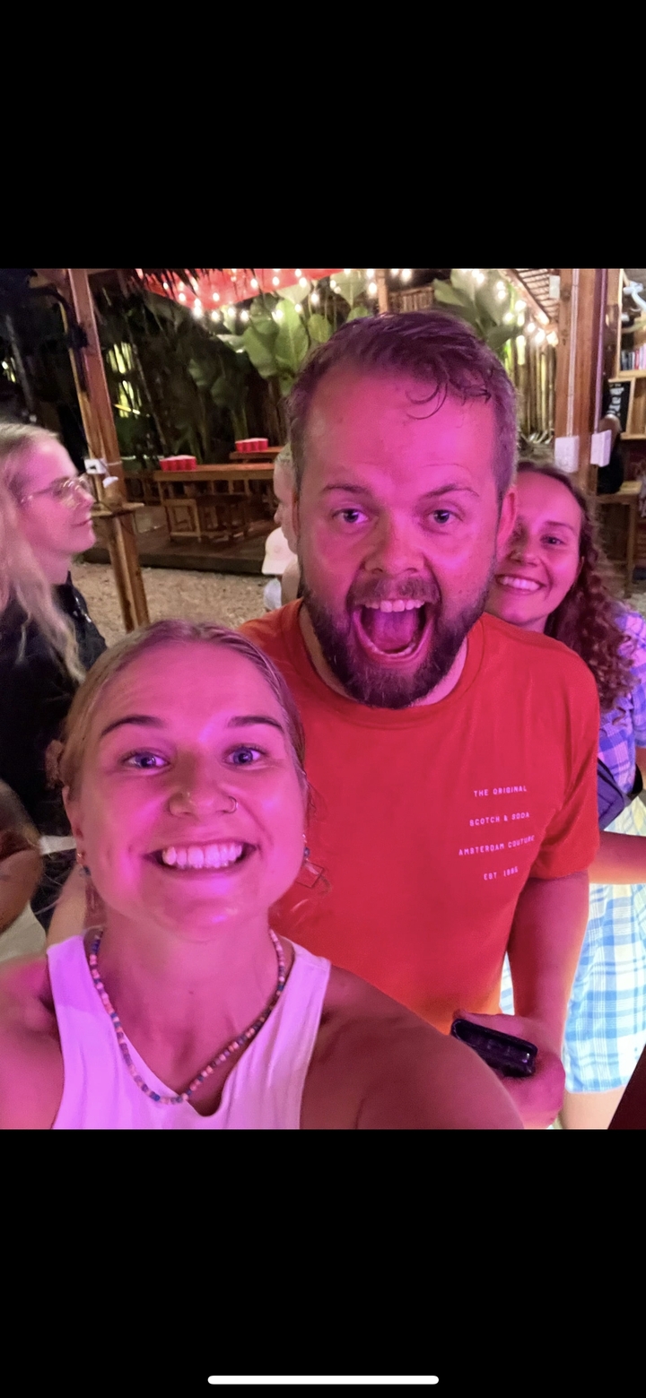 Des gens excités qui prennent la pose serrés les uns contre les autres la nuit.