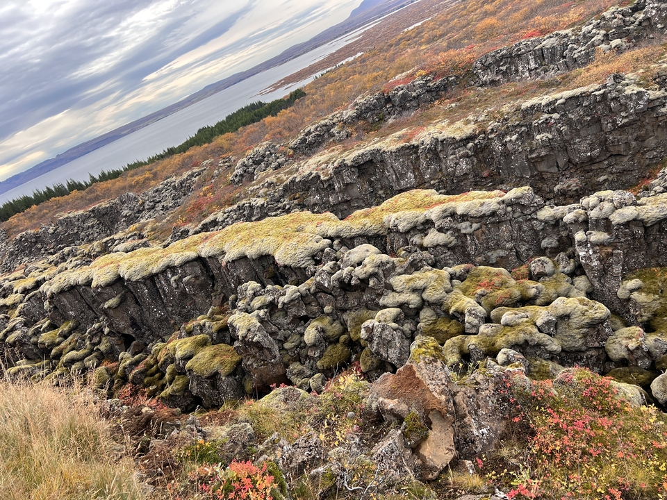 Landscape with autumn-colored rocky terrain and a lake.