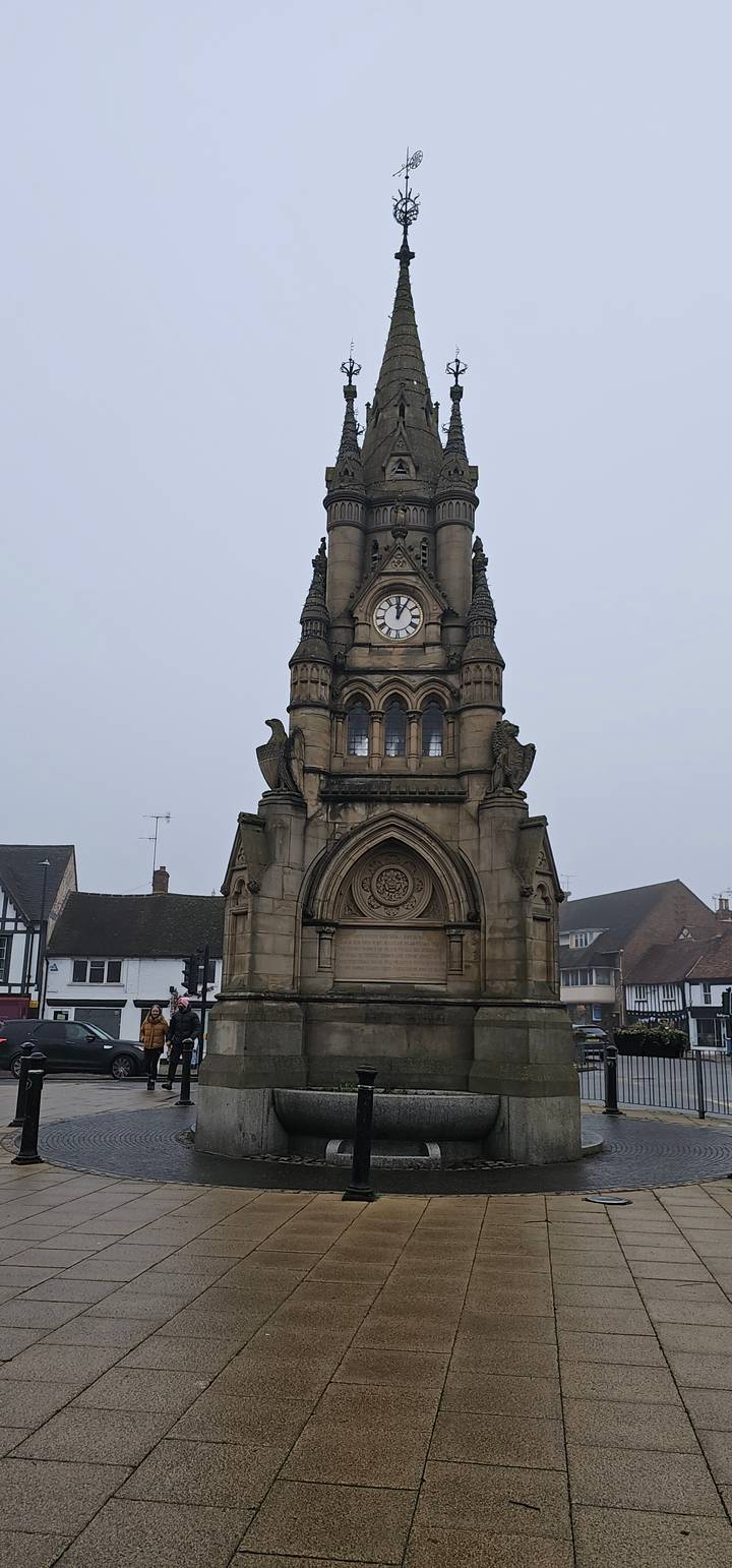 A tall stone clock tower with intricate designs.