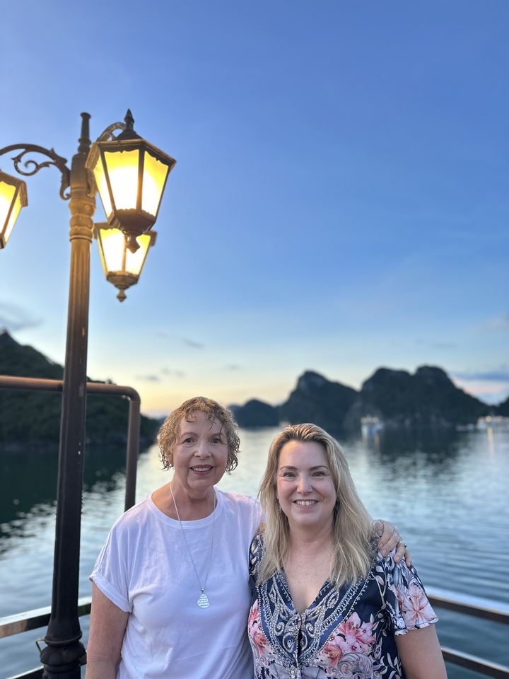 Femmes souriantes avec une belle baie et des formations calcaires en arrière-plan.