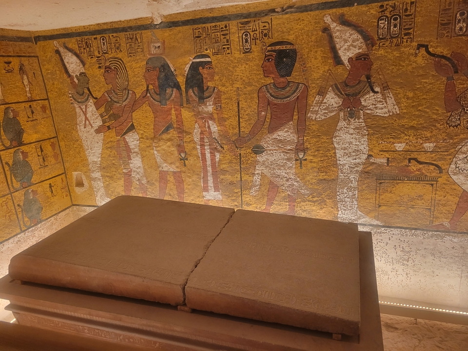 Colorful ancient Egyptian mural depicting figures and symbols.