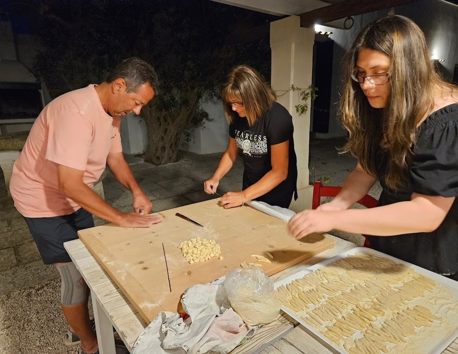 Three people making pasta together.