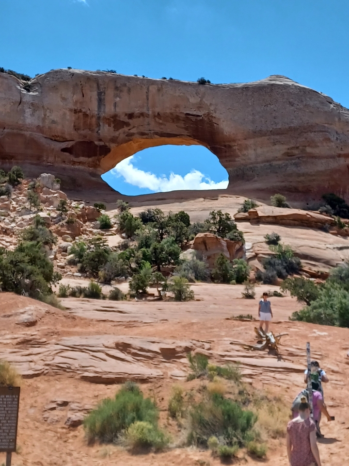 Person standing under a natural rock arch.