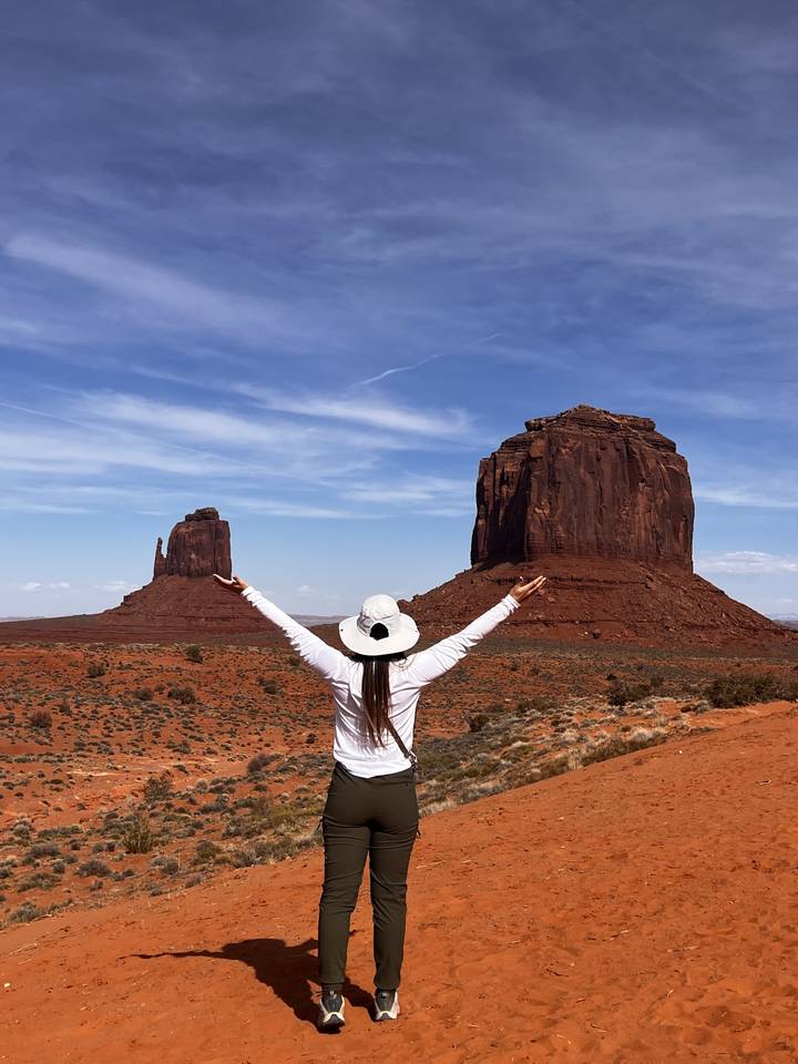 Person with outstretched arms in a desert setting.