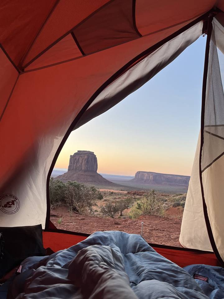 View from inside a tent overlooking a desert landscape.