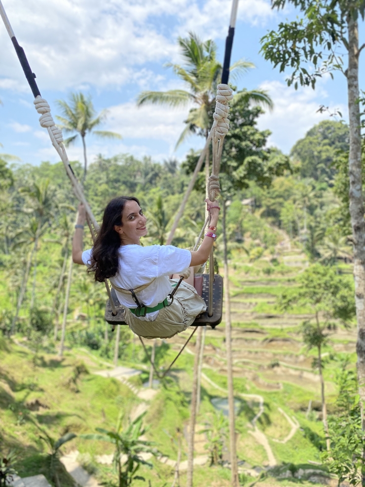 Woman on a swing overlooking tropical landscape
