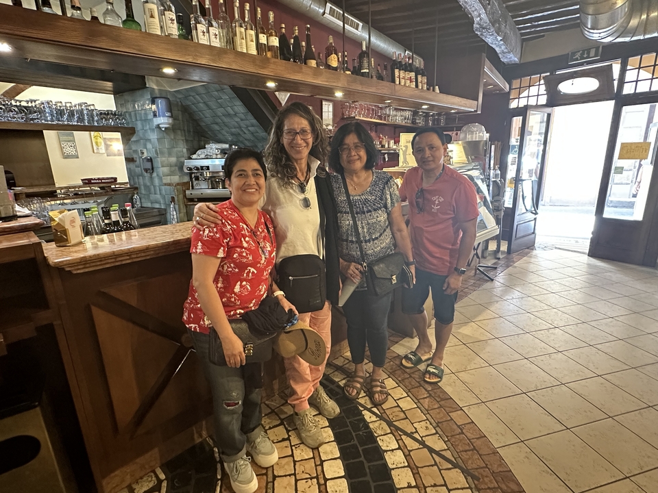 A group of people posing inside a cozy Italian cafe.