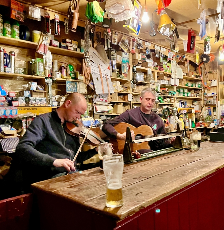 Two musicians performing in a pub setting.