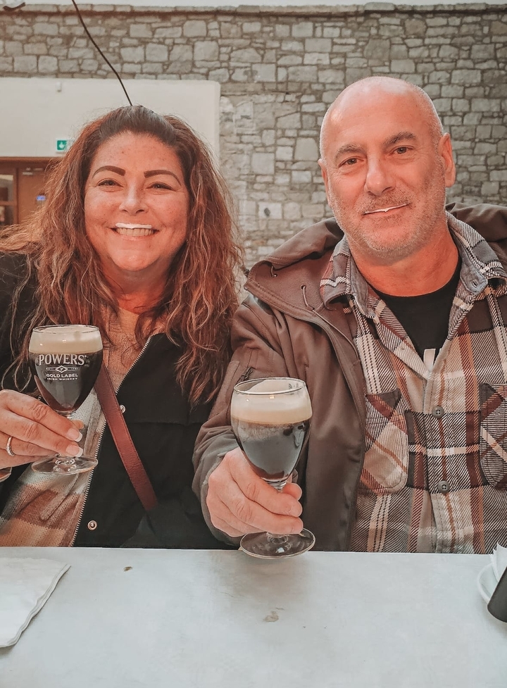 Couple holding glasses of stout beer.