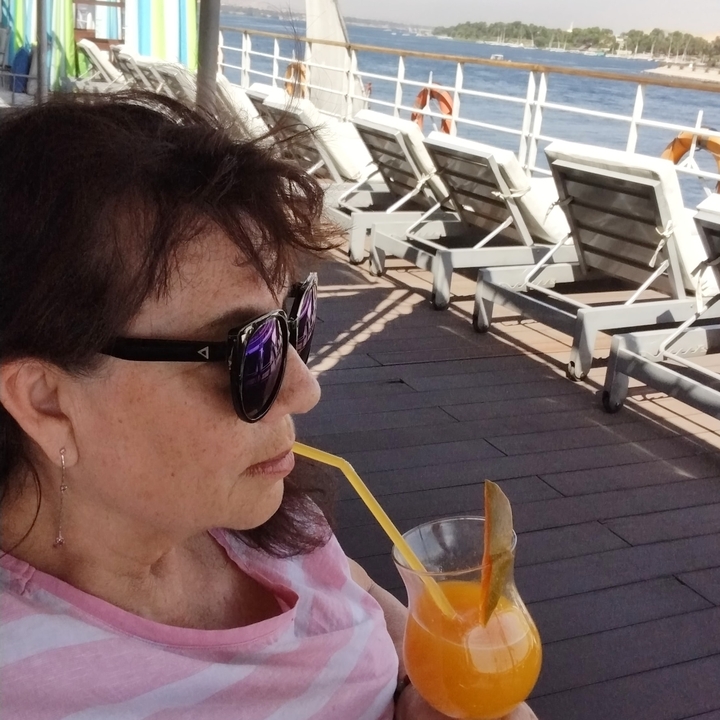 Person drinking a beverage on a deck.