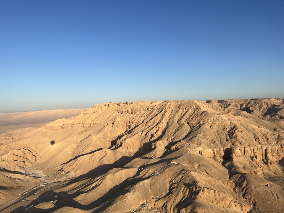 Wide view of desert mountains under a blue sky.