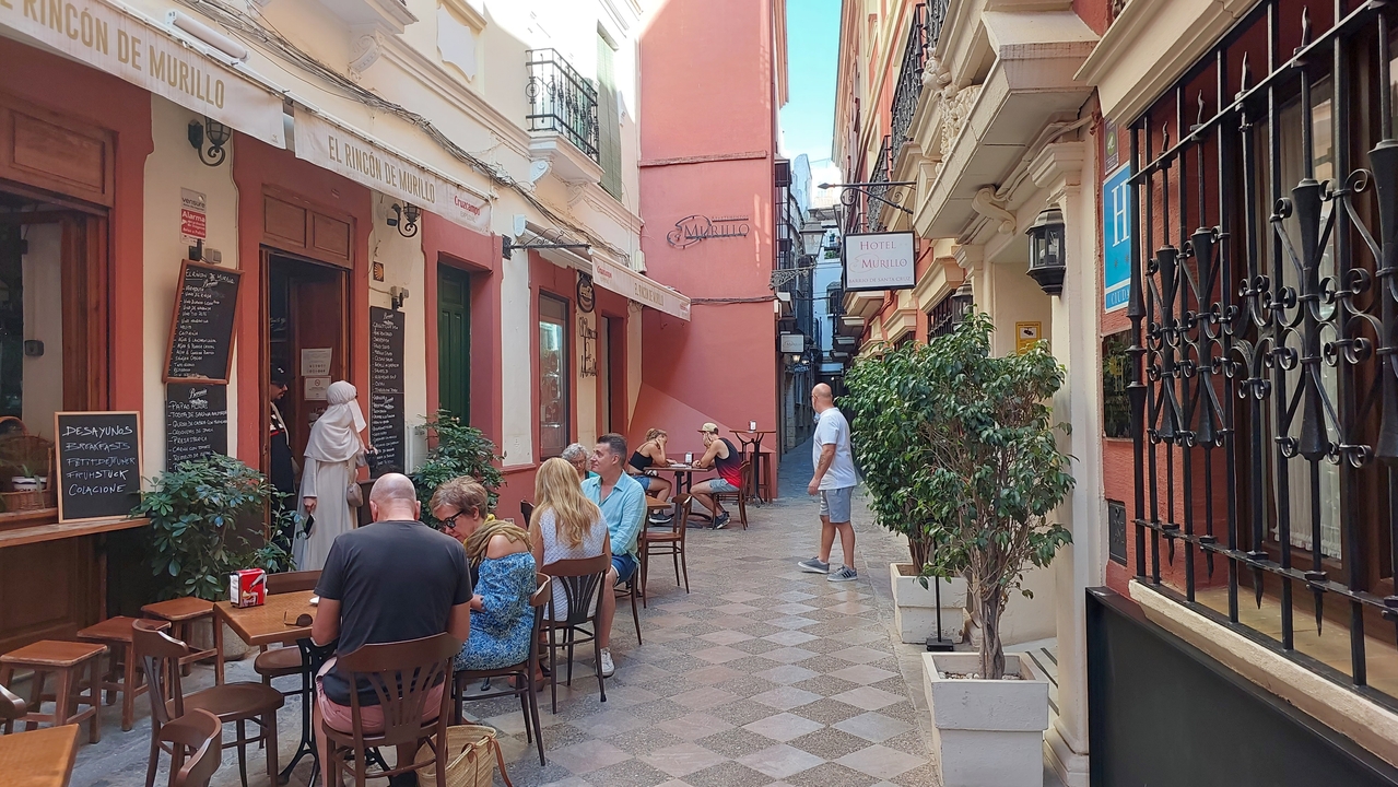 People dining outdoors on a cobbled street.