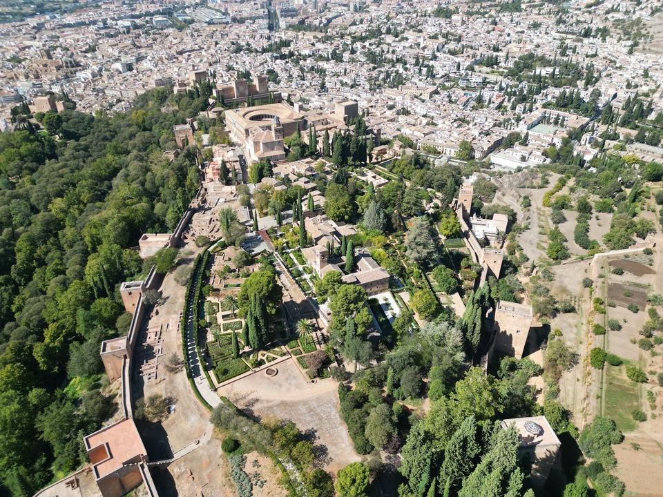 Aerial view of a historic complex surrounded by greenery.